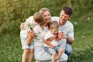 Family with cute little child. Father in a white shirt. Sunset background.